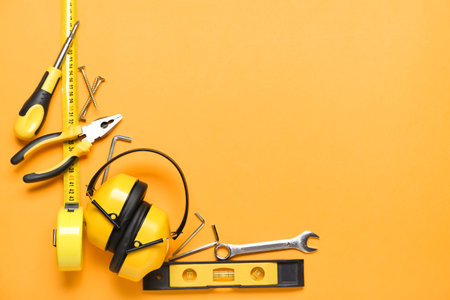 Frame made of builder's tools with hearing protectors on color backgroundの写真素材