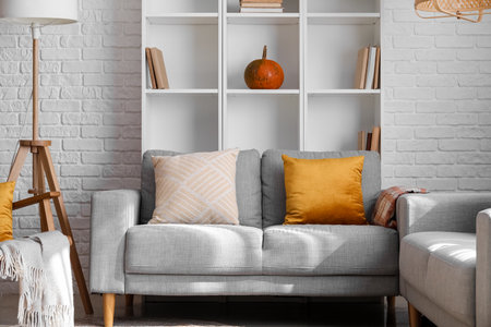 Interior of modern living room with gray sofa and shelving unit