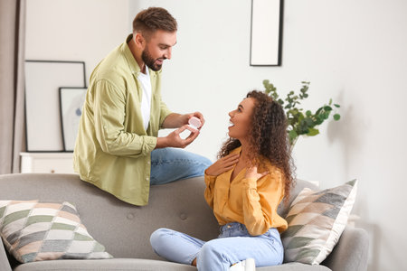Young man proposing to his girlfriend at home