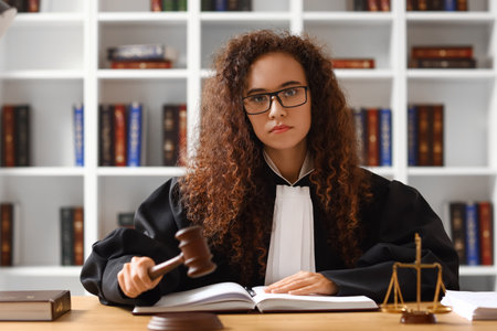 Female judge with gavel at workplace in courtroom