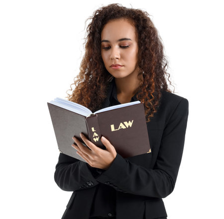 Young female judge with law book on white background