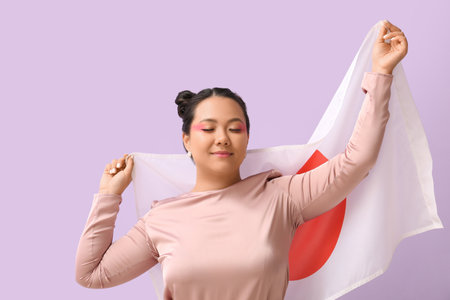 Beautiful young Asian woman with flag of Japan on color backgroundの写真素材