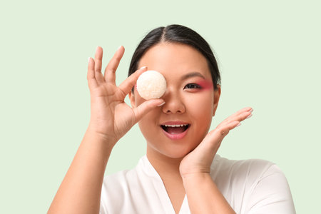 Beautiful Asian woman with tasty Japanese mochi on color backgroundの写真素材