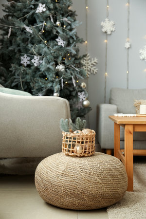Basket with Christmas decor on pouf in living roomの写真素材