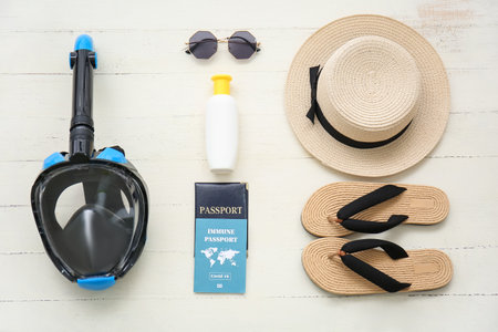 Female beach accessories with snorkeling mask and immune passport on white wooden backgroundの写真素材