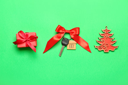 Key from new house with Christmas tree and gift on green backgroundの写真素材