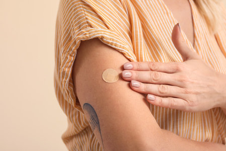 Mature woman with applied nicotine patch on color background, closeup. smoking cessation