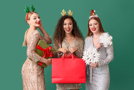 Beautiful young women with Christmas gifts on color backgroundの写真素材