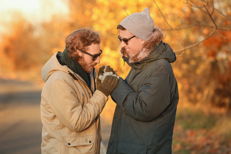 Happy gay couple in autumn parkの写真素材
