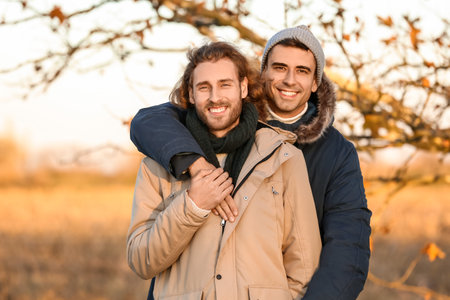 Portrait of happy gay couple in autumn parkの写真素材