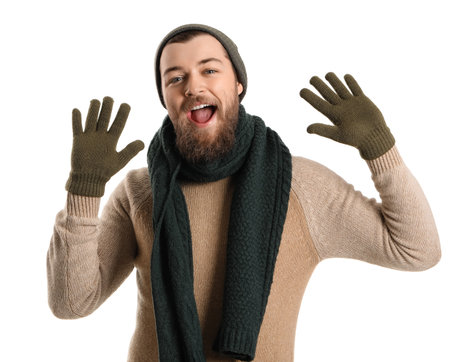 Young bearded man in warm gloves, hat and scarf on white backgroundの写真素材