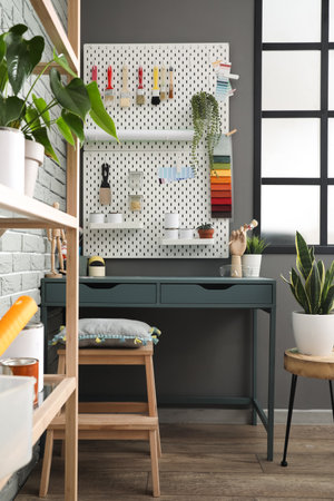 Decorator's workplace with different tools near gray wall in room interiorの写真素材