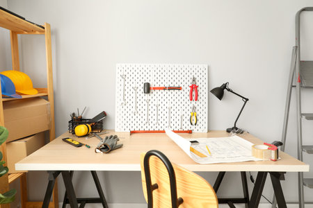 Workplace with modern tools and pegboard near light wallの写真素材