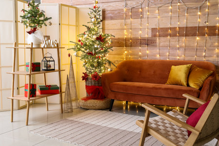 Interior of stylish living room with red sofa, Christmas trees and glowing lightsの写真素材