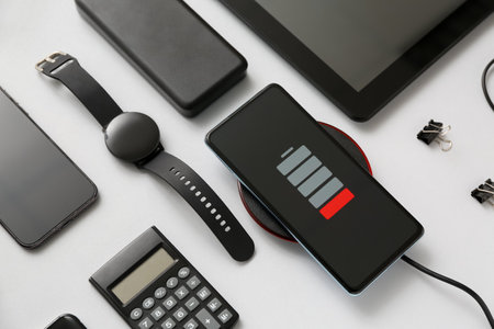 Modern gadgets with uncharged mobile phone and calculator on gray background, closeupの写真素材
