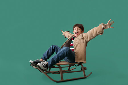 Sledding little boy on color backgroundの写真素材