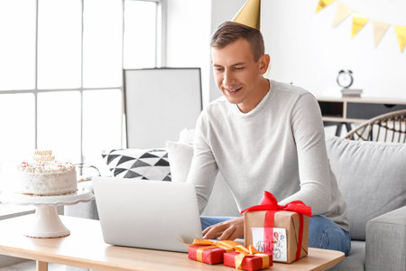 Young man celebrating Birthday online at home due to Coronavirus epidemicの写真素材