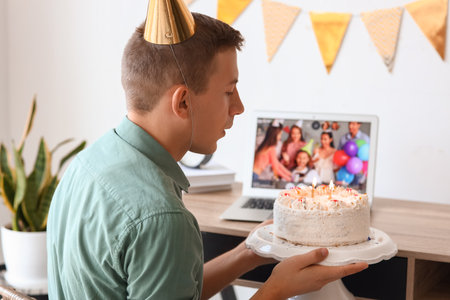 Young man celebrating Birthday online at home due to Coronavirus epidemicの写真素材