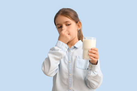 Little girl with lactose intolerance on color backgroundの写真素材