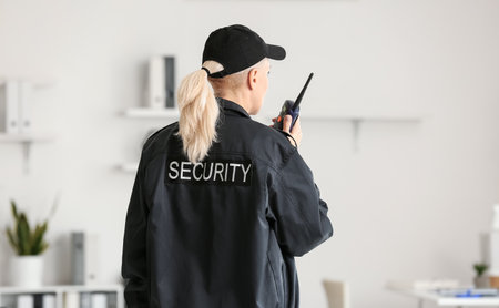 Female security guard with radio transmitter in office