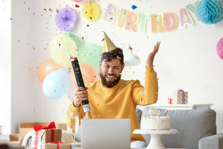 Young man celebrating birthday at home due to coronavirus epidemicの写真素材
