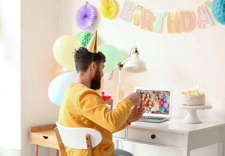 Young man celebrating birthday at home due to coronavirus epidemicの写真素材