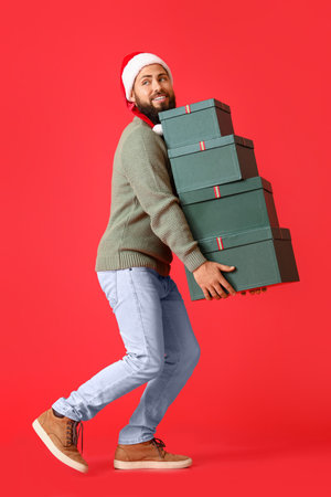 Walking man with Christmas gifts on color backgroundの写真素材