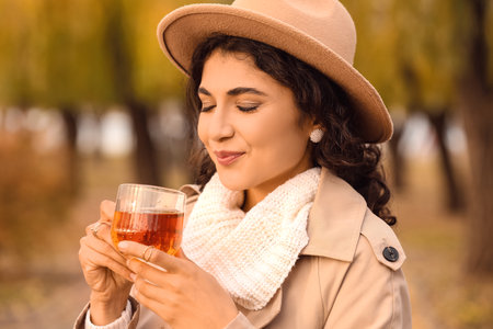 Beautiful woman drinking tea outdoorsの写真素材