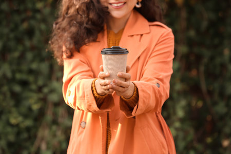 Beautiful woman drinking tea outdoorsの写真素材