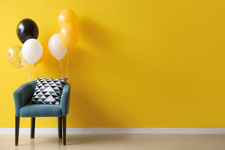 Stylish armchair with Halloween balloons near yellow wallの写真素材