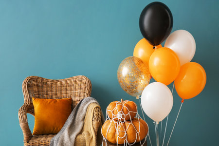 Halloween pumpkins, armchair and balloons near color wallの写真素材