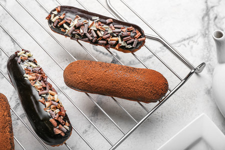 Grid with tasty chocolate eclairs on light background, closeupの写真素材