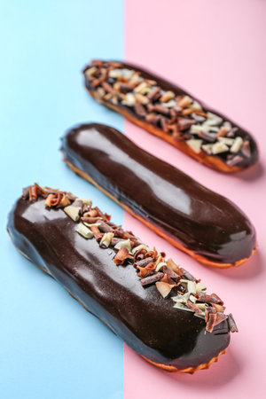 Tasty chocolate eclairs on color background, closeupの写真素材