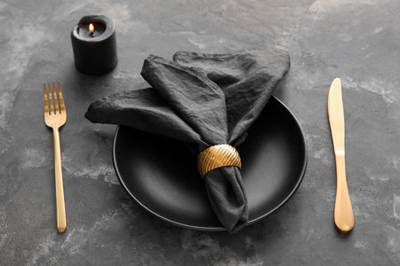 Stylish table setting and burning candle on grunge backgroundの写真素材