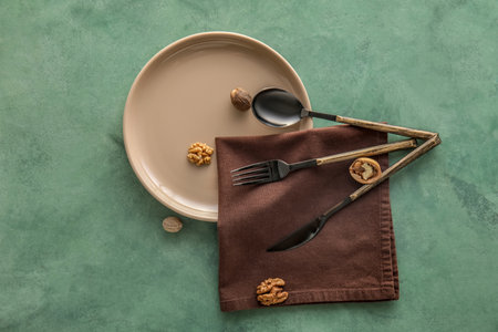 Table setting with scattered walnuts on green background