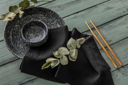 Table setting with chopsticks and eucalyptus branches on color wooden backgroundの写真素材