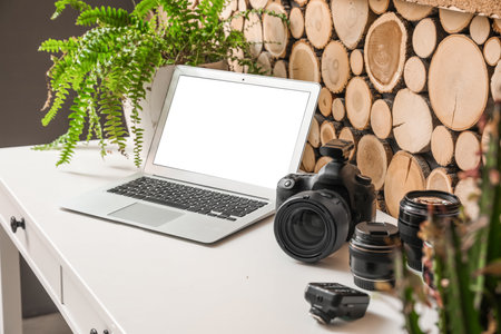 Photographer's workplace with laptop and equipment near wooden wallの写真素材