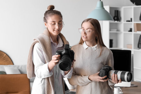 Female photographer and her assistant working in modern studioの写真素材