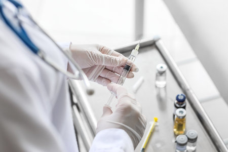Female doctor with syringe near table in clinic, closeup