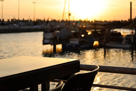 Closeup view of table with chair in open air restaurant near waterの写真素材