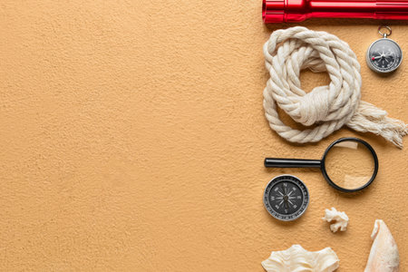 Compasses, magnifier, rope, flashlight and seashells on color backgroundの写真素材