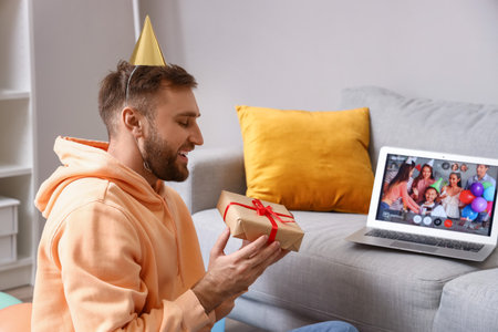 Happy man celebrating Birthday at home due to coronavirus epidemicの写真素材