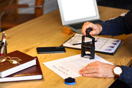 Male notary public attaching seal to document in office