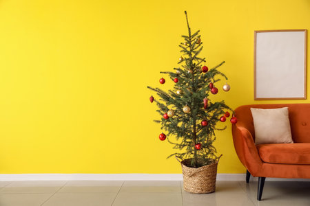 Interior of modern room with Christmas tree, sofa and blank photo frames on color wallの写真素材