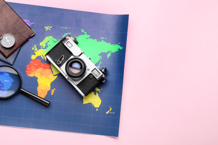World map, photo camera and compass on pink background, closeupの写真素材