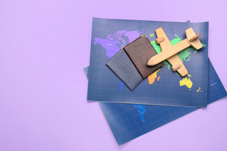 World maps, passports and wooden plain on lilac backgroundの写真素材