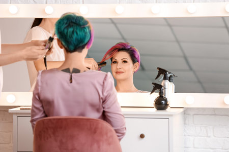 Stylist doing woman's hair in beauty salonの写真素材