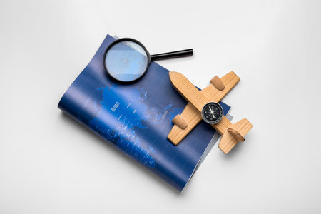 World map, wooden airplane, compass and magnifying glass isolated on white background