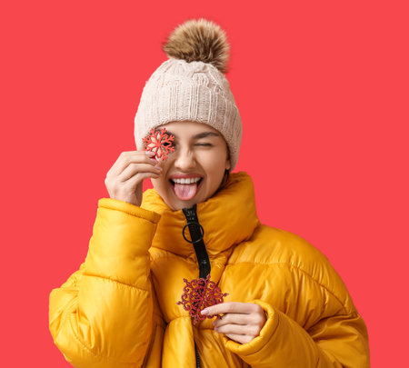 Funny young woman with snowflakes on color background