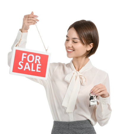 Female real estate agent with "For Sale" sign and key on white backgroundの写真素材